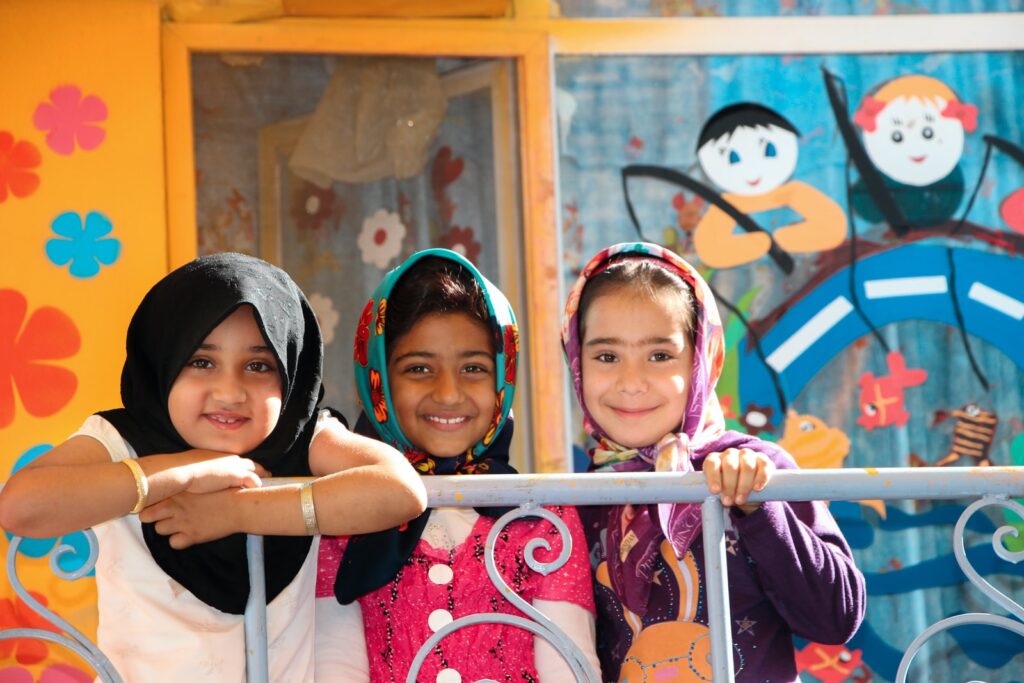 3 smiling young girls at pre school