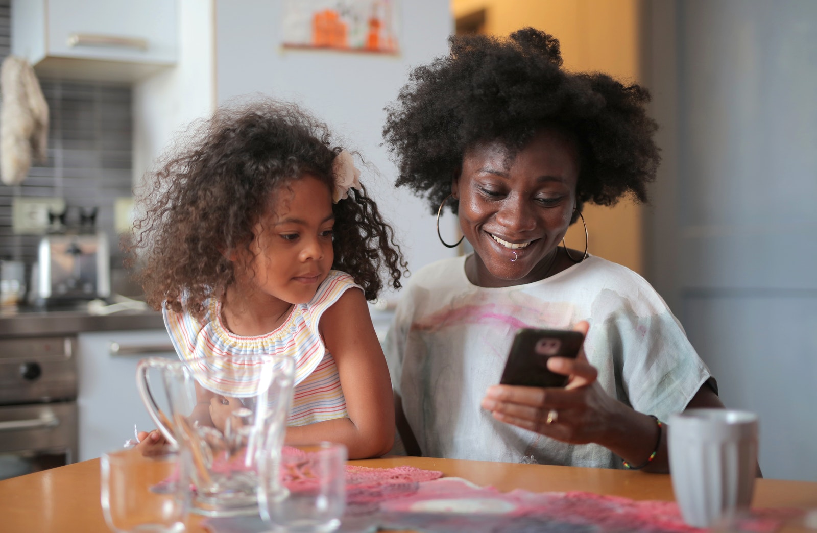 mother and daughter sitting on a chair in their kitchen